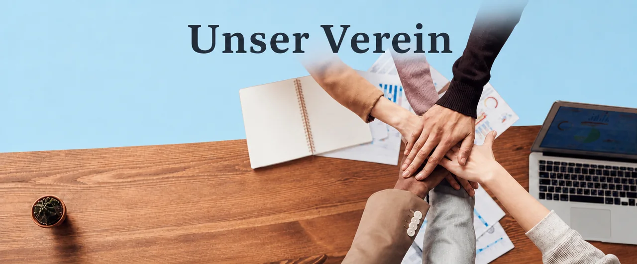 Fünf Hände übereinander auf einem Schreibtisch