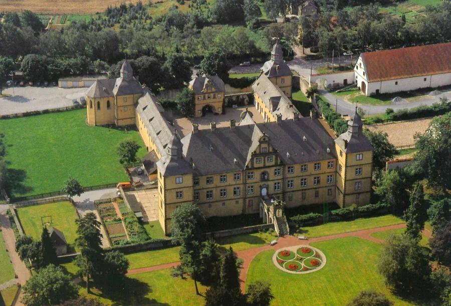Luftbild des Schlosses von der Rückseite, dahinter der Schlosspark